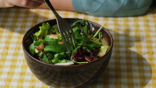 Heathy dinner. Diet cuisine. Woman eating summer salad of shrimp, basil, arugula, avocado and sprouted beans