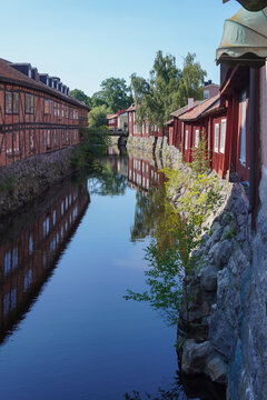 View along river with historic buildings and reflections