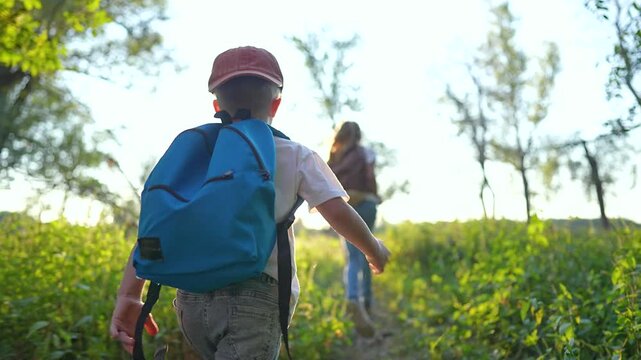 Family run through forest with backpacks. Kids and parents enjoying nature walk. Children with backpacks run along forest path. Family outdoor adventure in forest. Forest run with family and backpacks