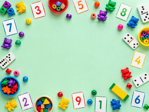 Colorful math toys number cards dice and learning pieces arranged around a mint green background with open copy space for preschool education counting games and playful early development