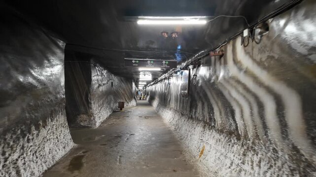 Walking through underground tunnel inside historic salt mine facility.