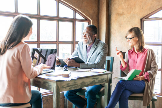 Diverse team meeting happily together.