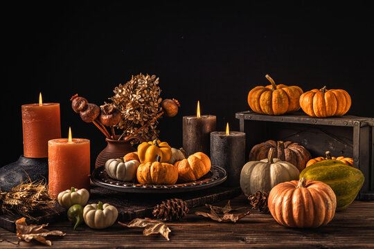 Autumn harvest bounty with glowing candles and rustic wooden table setting