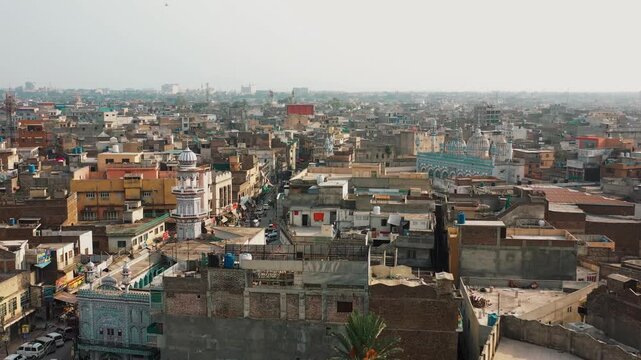 High angle elevated drone perspective of congested urban brick houses, flat rooftops, and Islamic architecture stretching to the horizon.