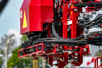 Agricultural field sprayer folded boom mechanism for pesticide application. Modern crop protection machinery frame assembly with hydraulic hoses and farming transport equipment technical detail. © NastyaPhoto