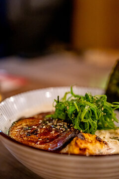 Close-up of miso ramen bowl topped with seared pork chashu and scallion. Comforting Japanese ramen concept for restaurant dining and cozy seasonal meals.