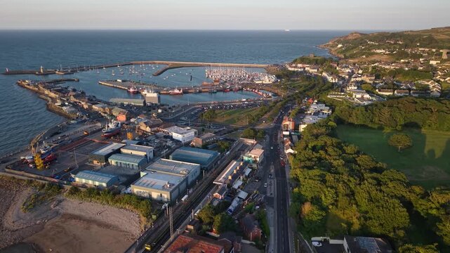 Warm evening drone birds eye of Howth Harbour and picturesque coastal town, Ireland
