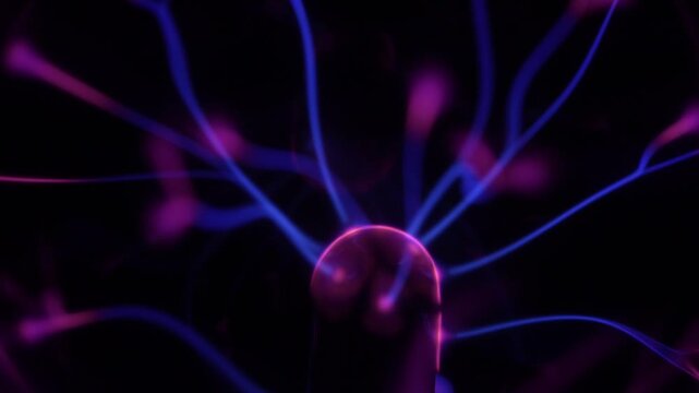 Close-up of a plasma ball coil. The plasma ball creates purple energy beams.