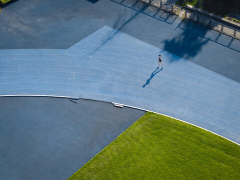 Aerial view of a runner training on the blue track of the athletics arena in Krakow, Lesser Poland Voivode, Poland.