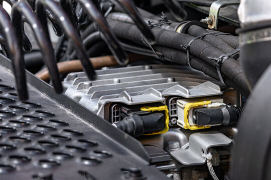 Semi truck engine electronic control unit with wiring harness plugs. Heavy duty commercial transport vehicle ecu aluminum housing component and long haul dremtruck technical details closeup.