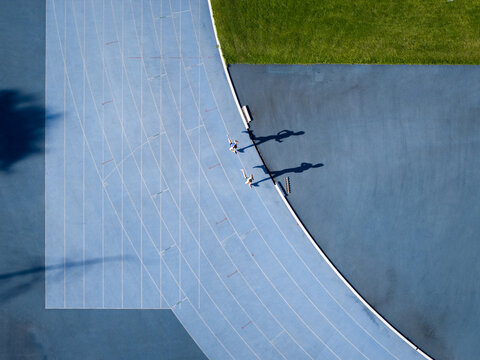 Aerial view of a runner training on the blue track of the athletics arena in Krakow, Lesser Poland Voivode, Poland.