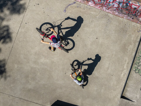 Aerial view of two children riding bicycles on a concrete surface in Henryk Jordan Park in Krakow, Wojewodztwo malopolskie, Poland.