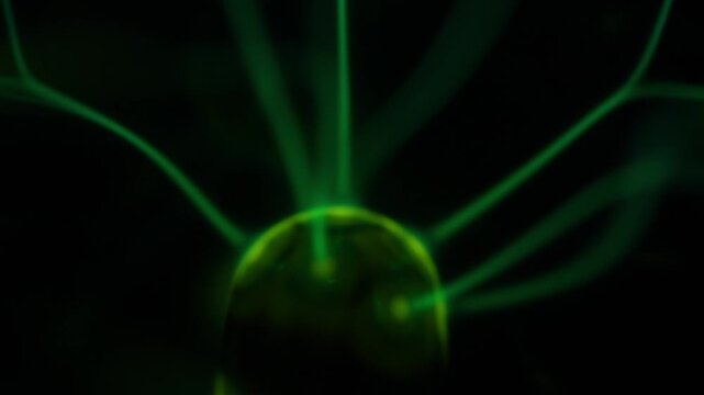 A close-up of the plasma ball coil during operation. The color of the electric rays created by the coil is a shade of green.