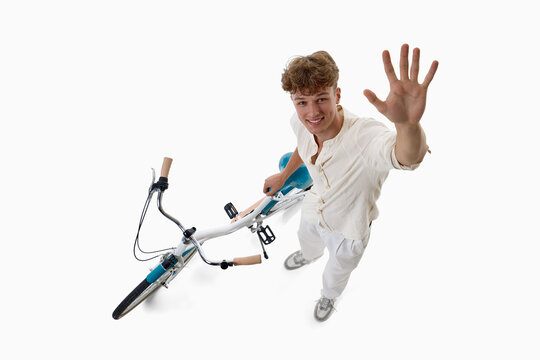 Fallen young cyclist reaches for help beside bicycle from overhead view. Concept of cycling accident response, roadside assistance, personal mobility safety awareness.