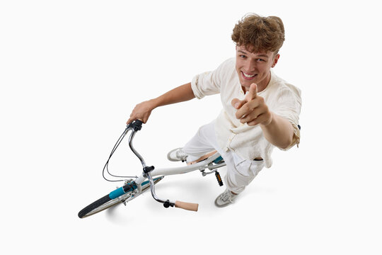 Fallen young cyclist gives thumbs up beside bicycle from overhead view. Concept of recovery after minor accident, personal resilience, positive coping with setbacks.