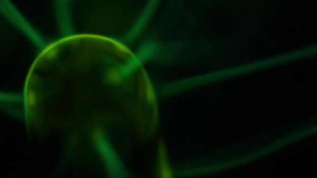 A close-up of the plasma ball coil during operation. The color of the electric rays created by the coil is a shade of green.