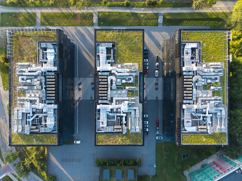 Aerial view of an AI data center with extensive HVAC cooling systems on green roofs, surrounded by parking and urban greenery in Krakow, Lesser Poland Voivode, Poland.