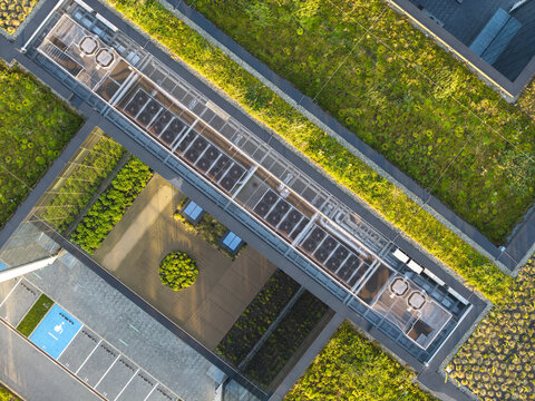 Aerial view of the AI data center HVAC cooling system installed on a modern green roof with lush vegetation and a parking area in Krakow, Lesser Poland Voivode, Poland.