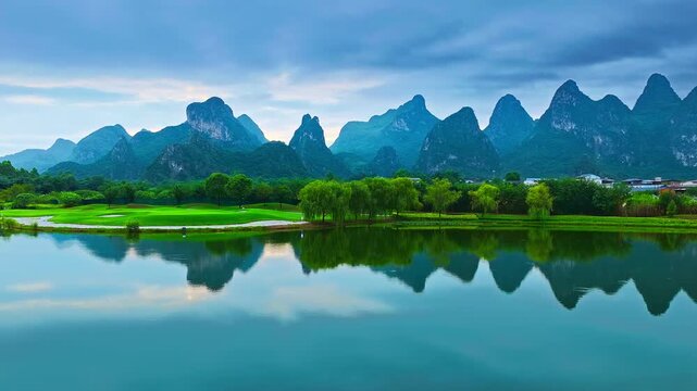 Guangxi, China, featuring iconic limestone karst peaks, a calm lake reflection, lush greenery, and a golf course beneath a cloudy sky.