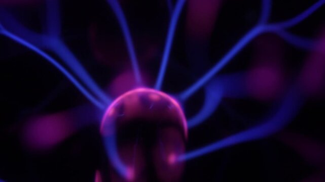 Close-up of the plasma ball coil during operation. The plasma ball generates purple-hued rays.