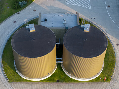 Aerial view of Wawel SA production facility featuring two large industrial storage tanks surrounded by paved paths and green grass in Dobczyce, Malopolskie, Poland.