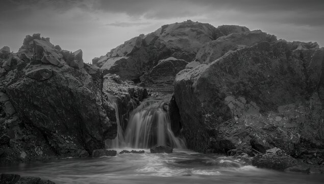 Waterfall Cascading Between Rocky Outcrops in Monochrome Setting