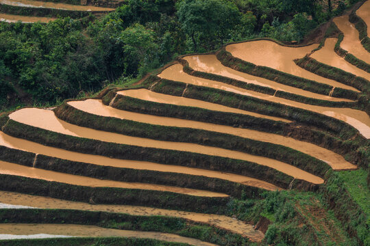 The pouring water season makes the terraced fields of Y Ty, Lao Cai province, Vietnam appear with brown soil blending with the beautiful sky