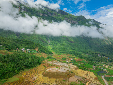 The pouring water season makes the terraced fields of Y Ty, Lao Cai province, Vietnam appear with brown soil blending with the beautiful sky