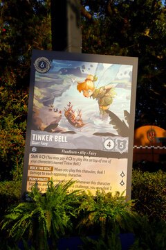 
Display of a giant Disney Lorcana Tinker Bell card at a theme park
