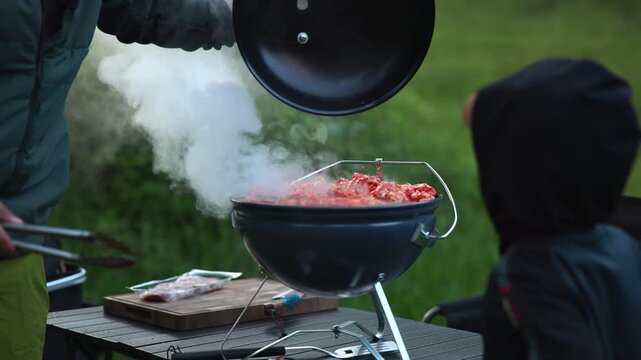 Father and son cooking barbecue outdoors