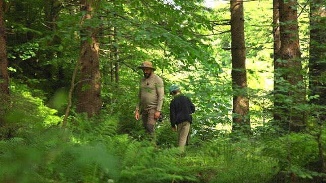 Father and son overlanding in a dense green forest