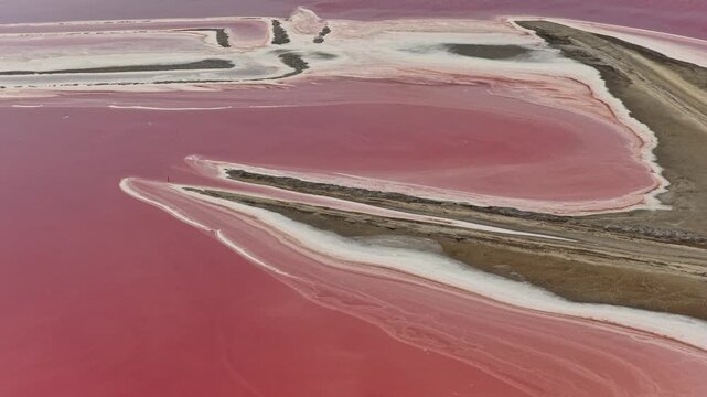Aerial view of pink salt evaporation ponds and white salt deposits in Camargue near Aigues-Mortes, southern France