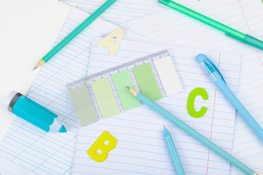 Back-to-school concept, flat lay composition of school supplies on a green background