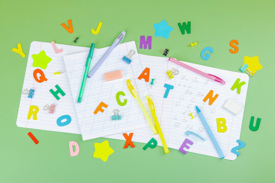 Back-to-school concept, flat lay composition of school supplies on a green background