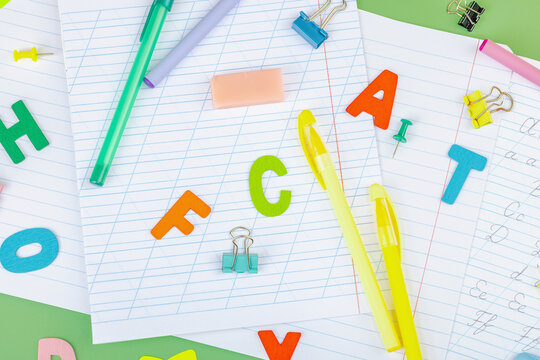 Back-to-school concept, flat lay composition of school supplies on a green background