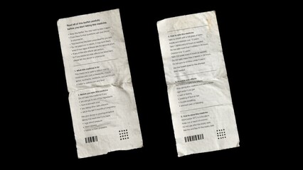 Fototapeta premium Two folded medicine instruction leaflets isolated on black