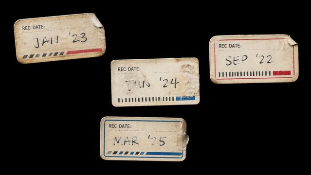 Four worn record date stickers isolated on black background