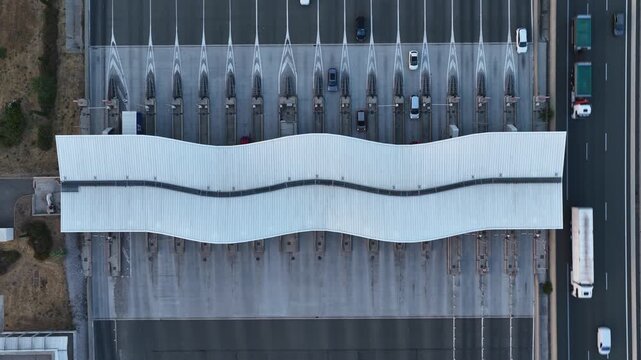 Baillargues, France &ndash; 18 July 2026: Top-down drone view of a motorway toll plaza with symmetrical traffic lanes and distinctive wave-shaped canopy in southern France.