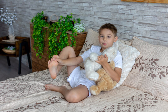 Cute little preschool child, cute blond boy, playing in bed with many teddy bears, handmade amigurumi toys, enjoying toy game