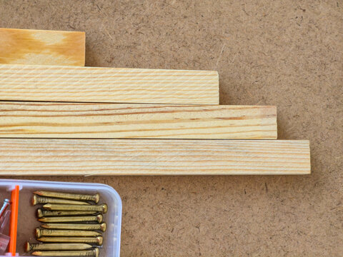 Wooden boards and nails on workbench surface for carpentry and diy construction background