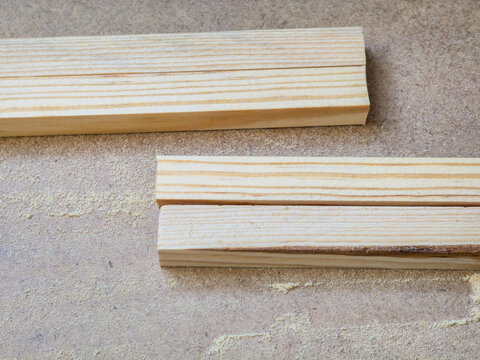 Pine wood boards on rough concrete surface with sawdust, construction material background