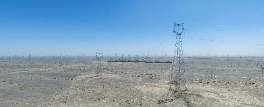 Vast Wind Farm And Power Transmission Towers In Gobi Desert Landscape