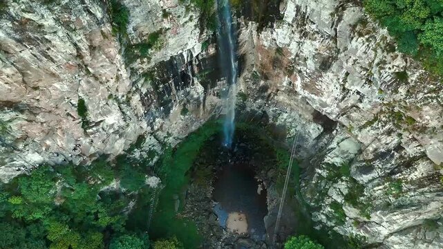 Rising Aerial Reveal of Via Ferrata Climbers and Xuedou Mountain Waterfall
