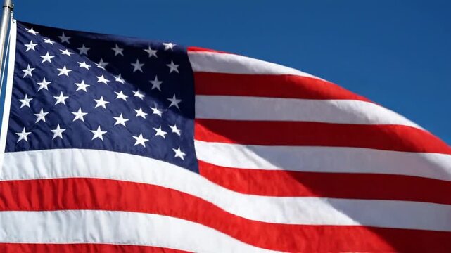 American flag waving in clear blue sky, patriotic symbol of freedom and democracy
