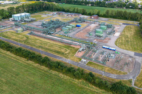 Aerial view of a hydrogen pilot project featuring industrial pipelines, storage tanks, and technical infrastructure surrounded by green fields in Hoogeveen, Drenthe, Netherlands.