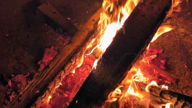 Night slow motion video of bonfire. Closeup of flame of burning wood on black background.