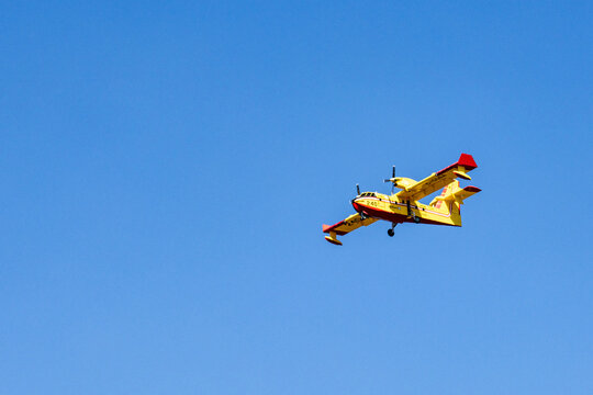 La Tuque, Quebec, 16 May 2026 : A yellow and red firefighting seaplane flies across a clear blue sky.