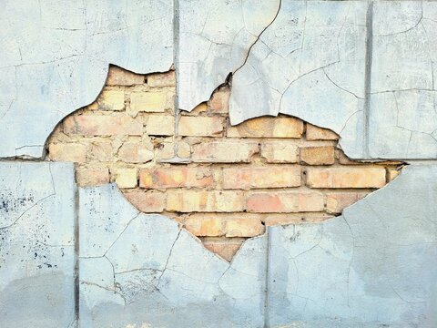 Cracked Plaster Wall Revealing Old Yellow Brick Masonry Texture