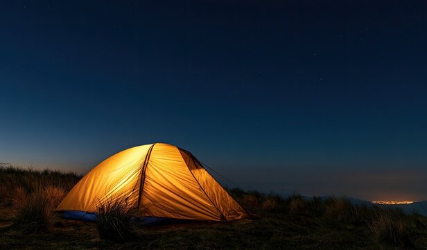Glowing tent on a grassy hill under a starlit, dark blue sky