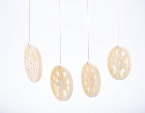 Several round white Palembang crackers hanging vertically on thin strings